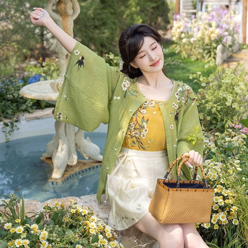 Modern Hanfu garden outfit with dense floral embroidered cardigan wrap style white skirt shorts and woven rattan handbag