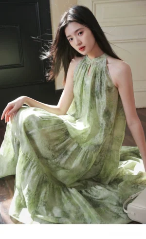 Model wearing a sage green tie dye modern Hanfu halter cheongsam maxi dress with a flowing floor length skirt in a vintage indoor setting
