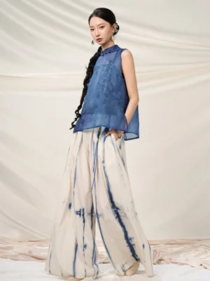 Model wearing modern Hanfu indigo tie-dye high-waist wide-leg pants with a flowing off-white and blue Chinese-style outfit