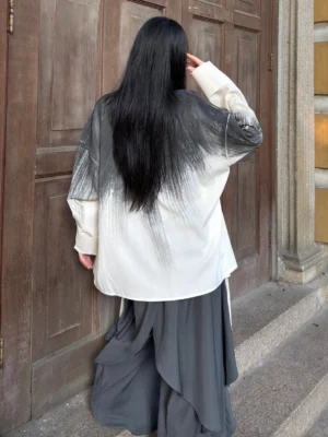 Back view of a Chinese style ink wash gradient long sleeve cardigan worn with a flowing dark grey layered skirt in a modern Hanfu outfit