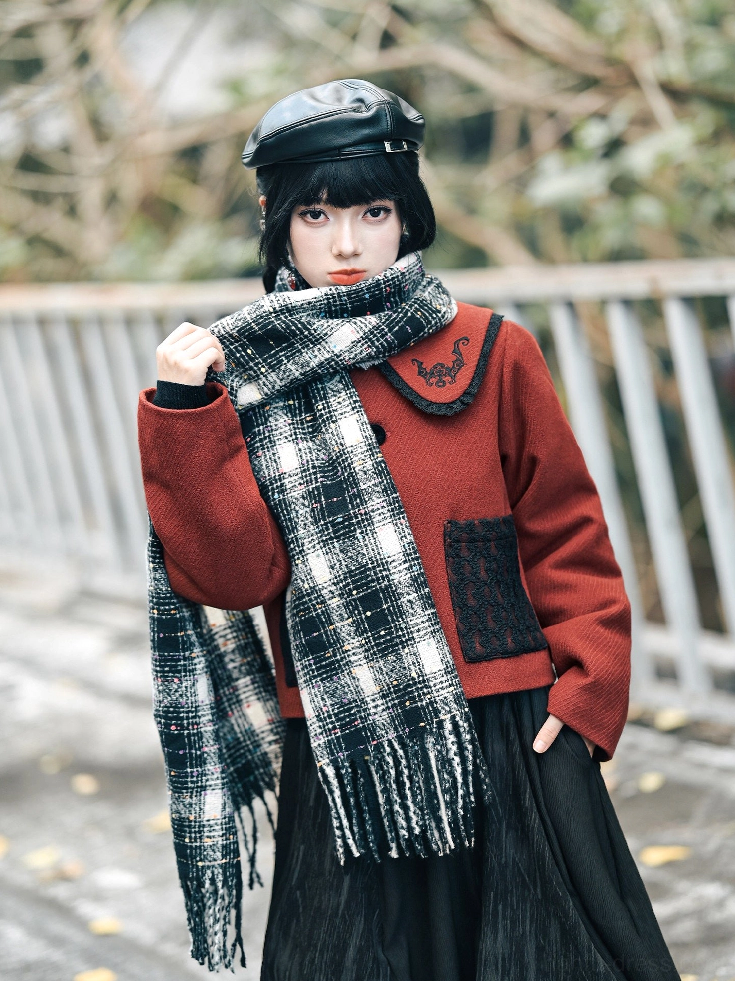 Close-up of the red wool blend modern Hanfu jacket featuring detailed black lucky bat embroidery on the rounded doll collar and textured fabric