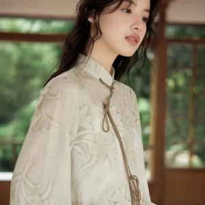 Close up side view of a light khaki modern Hanfu cropped top with leaf floral jacquard texture stand collar and brown rope ties