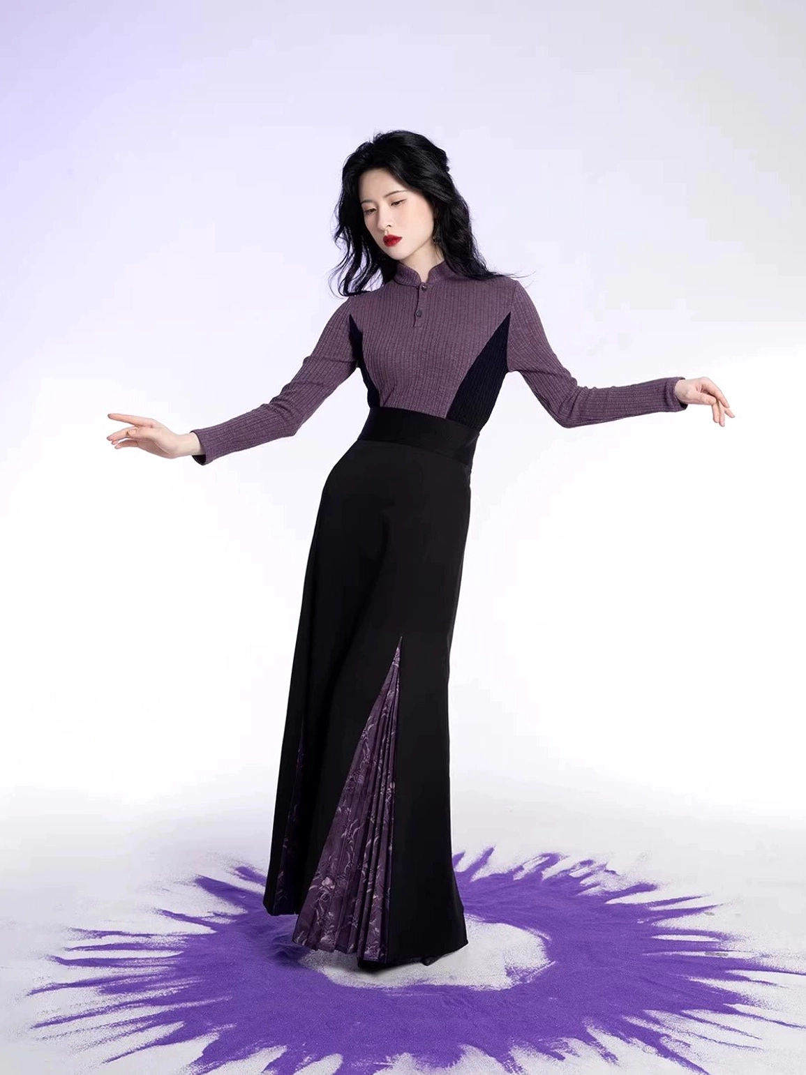 Side view of fitted modern Hanfu knit top and black long skirt showing the flowing purple pleated side slit detail