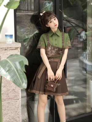 Modern hanfu outfit styled with an embroidered army green shirt, brown mamianqun skirt, botanical details, and matching small brown handbag beside a café storefront