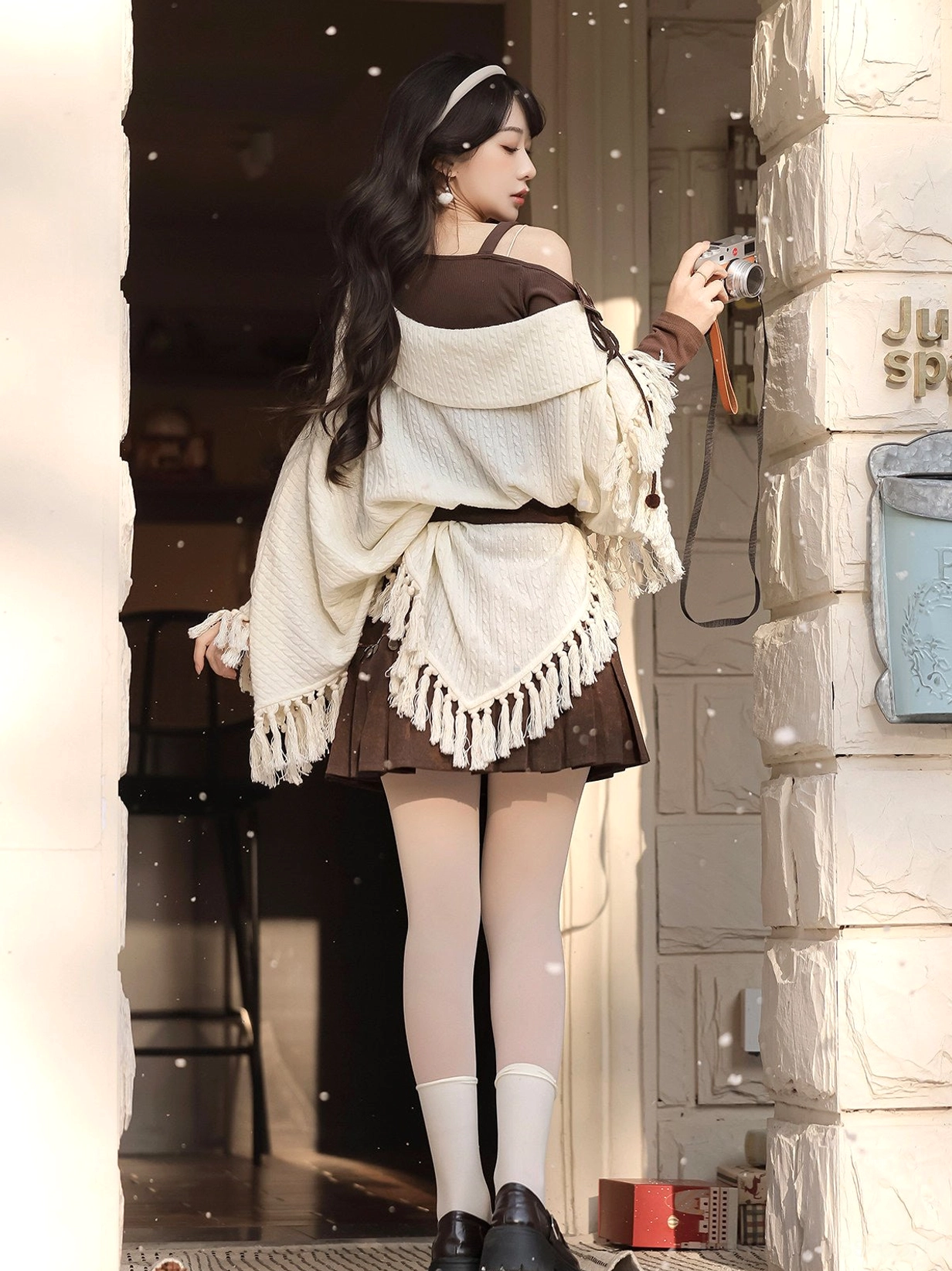 Back view of modern Hanfu off-shoulder knit cloak outfit with asymmetrical cape hem tassel trim and brown mini skirt