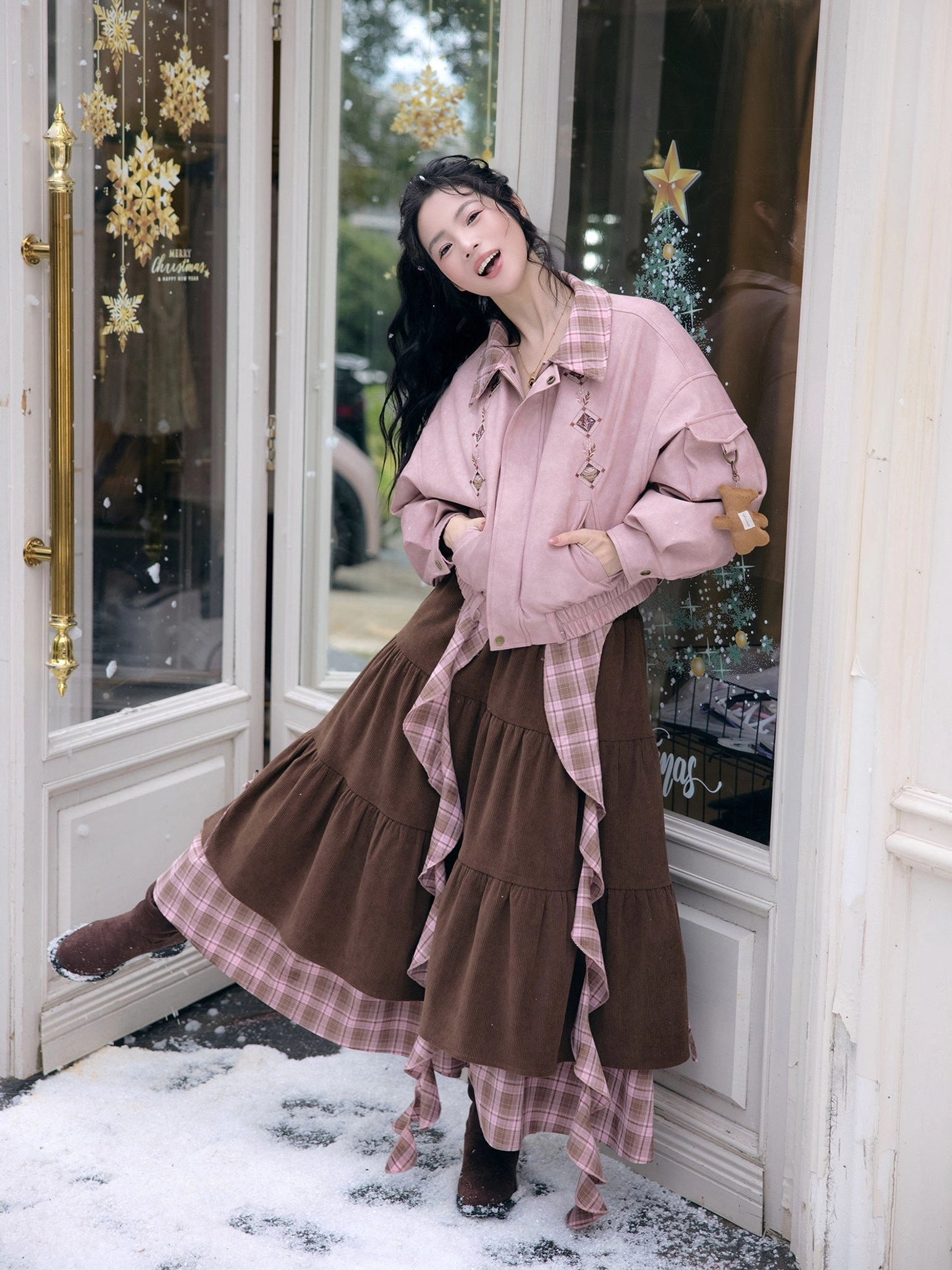 Modern Hanfu pink cropped jacket and brown ruffle midi skirt outfit shown from the side at a French-style shop door with plaid collar and layered skirt sash
