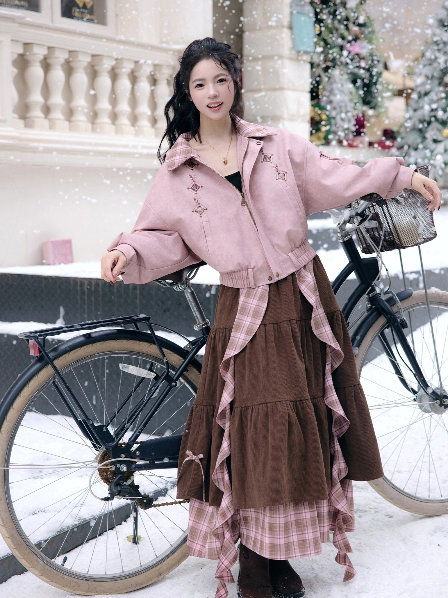 Full-body side view of a pink modern Hanfu cropped jacket and brown tiered skirt with elastic cuffs, shaped hem, and plaid layered trim