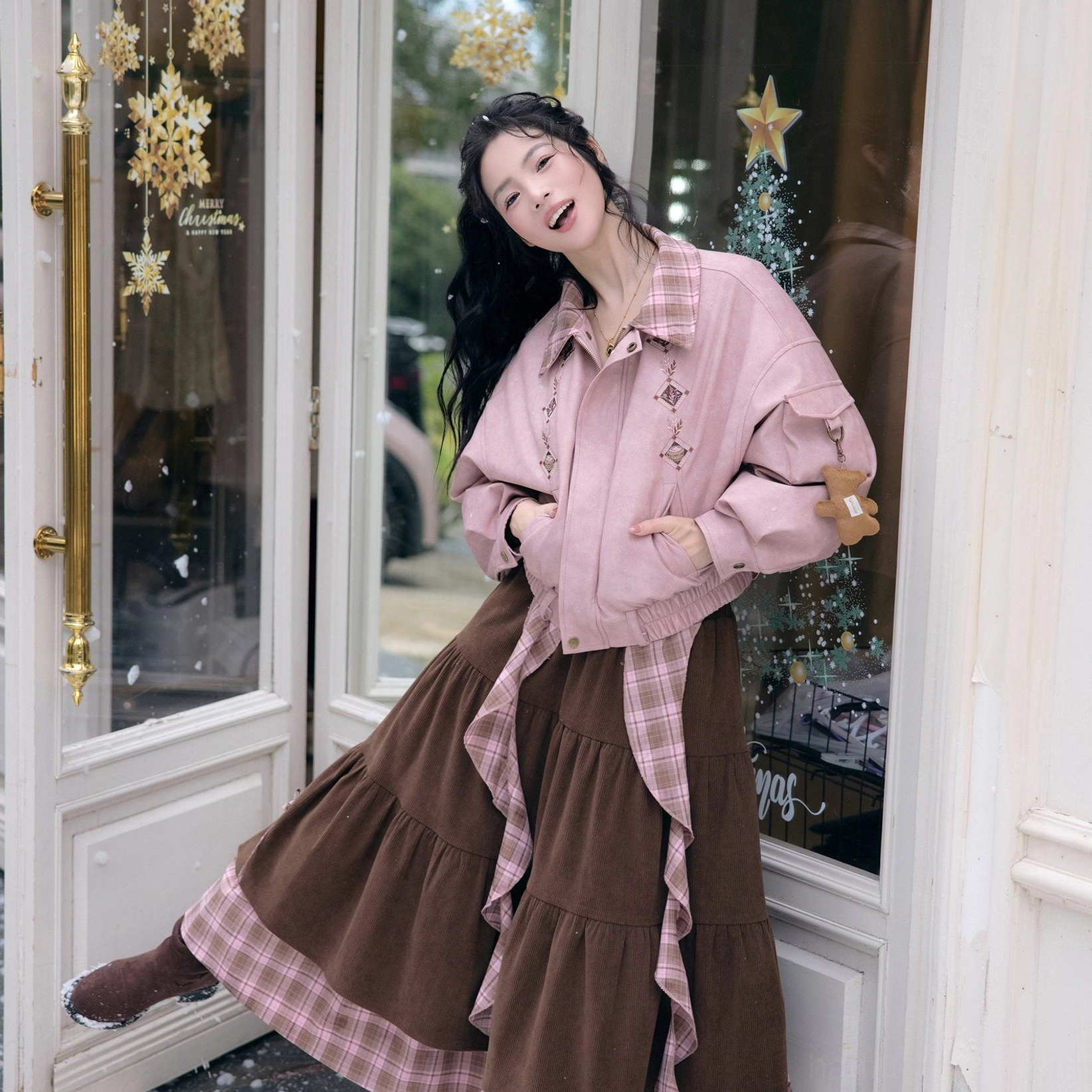 Full-body modern Hanfu pink cropped jacket and cinnamon brown ruffle skirt two-piece set with bear sleeve pendant styled at a decorated French-style shop door