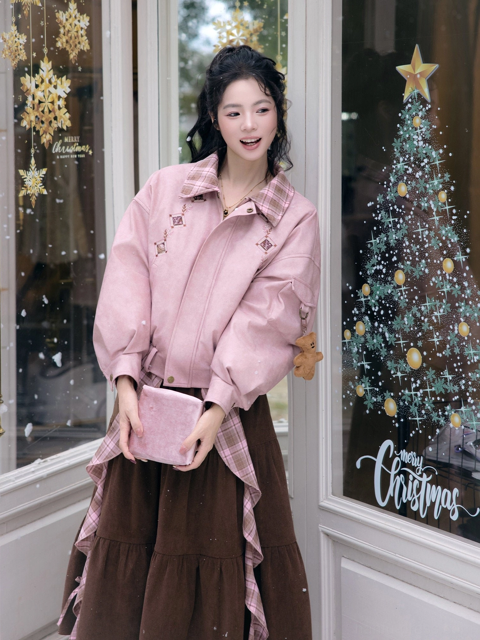Front three-quarter view of a modern Hanfu pink jacket and brown tiered skirt set with matching mini handbag and bear sleeve pendant