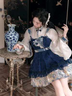 Modern Hanfu Chinese-style Lolita full set with off-white pipa sleeve top, navy embroidered suspender dress, layered ruffle hem, and white hair accessory in a vintage interior