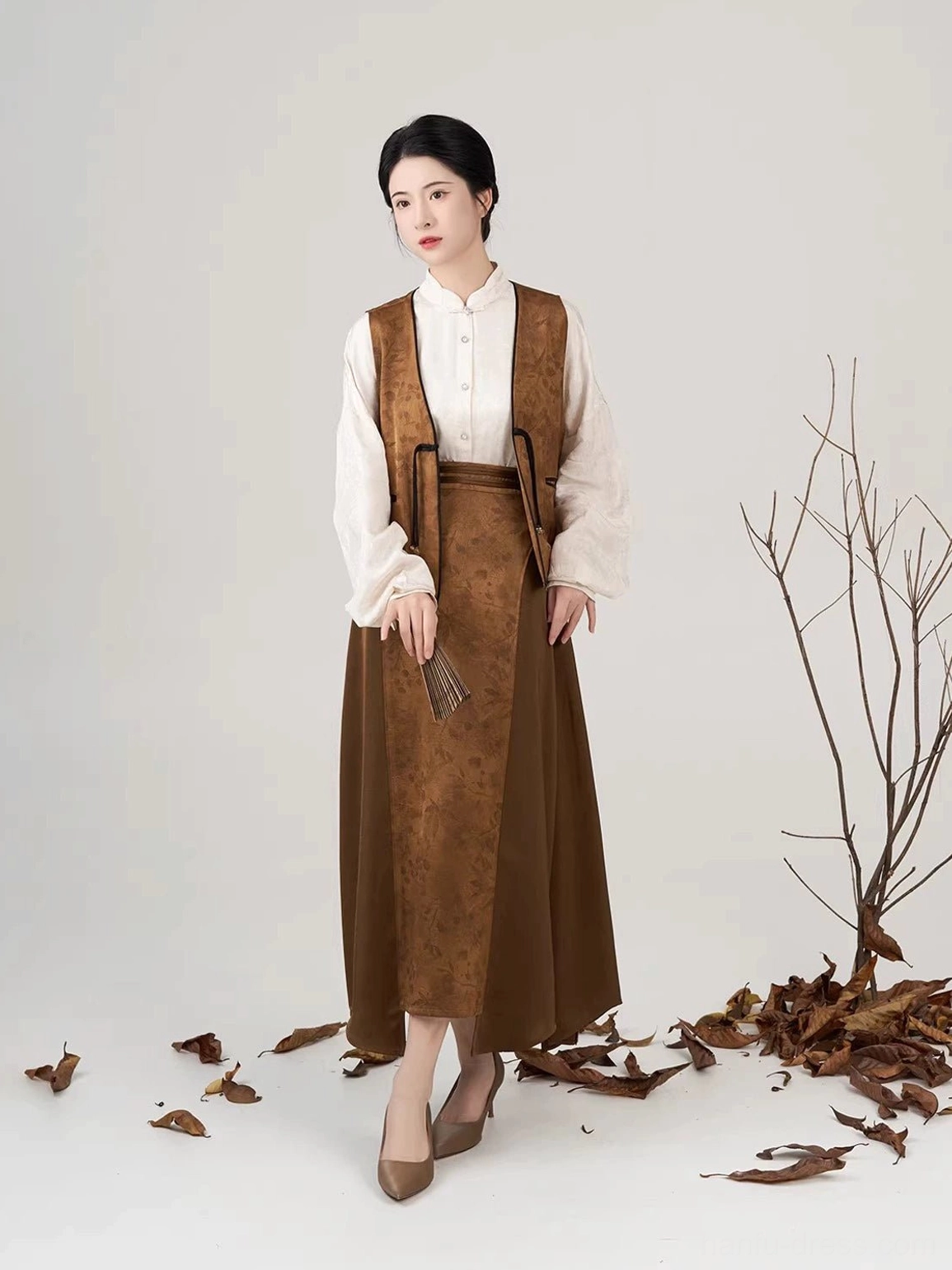 Modern Hanfu three-piece set with cream pipa sleeve shirt brown jacquard vest and long asymmetric skirt front view