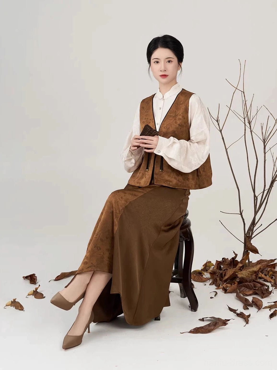 Women wearing a brown and cream Modern Hanfu pipa sleeve shirt vest and long skirt seated portrait