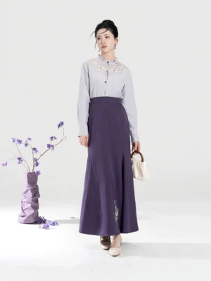 Front side view of a woman wearing a light grey embroidered Chinese-style blouse and dark purple mermaid skirt outfit