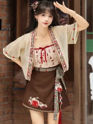 Three-quarter view of a playful modern Hanfu outfit with embroidered cardigan, apple print top, floral skirt, decorative sash, and tassel