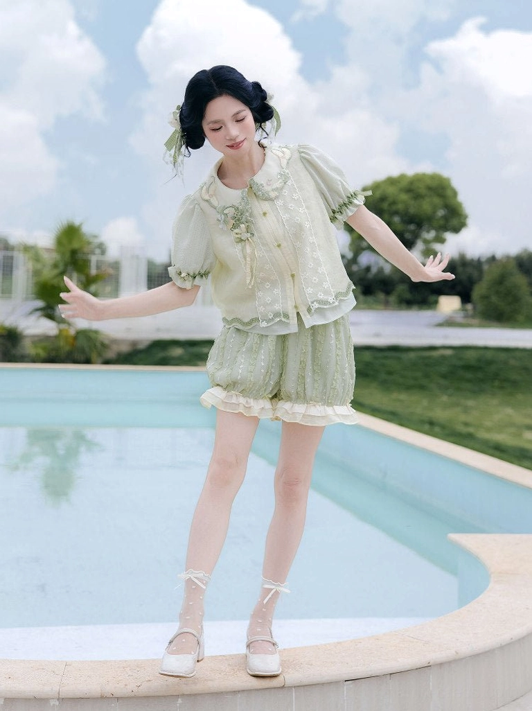 Three-quarter view of Meilong Jasmine modern Hanfu shirt and bloomers with embroidered doll collar, sheer lace front panel, and cream ruffled shorts hem