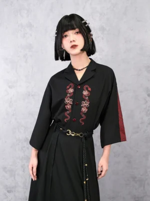 Three-quarter front view of a modern Hanfu black shirt with red snake and pink lotus embroidery, patterned three-quarter sleeves, and Chinese-inspired styling
