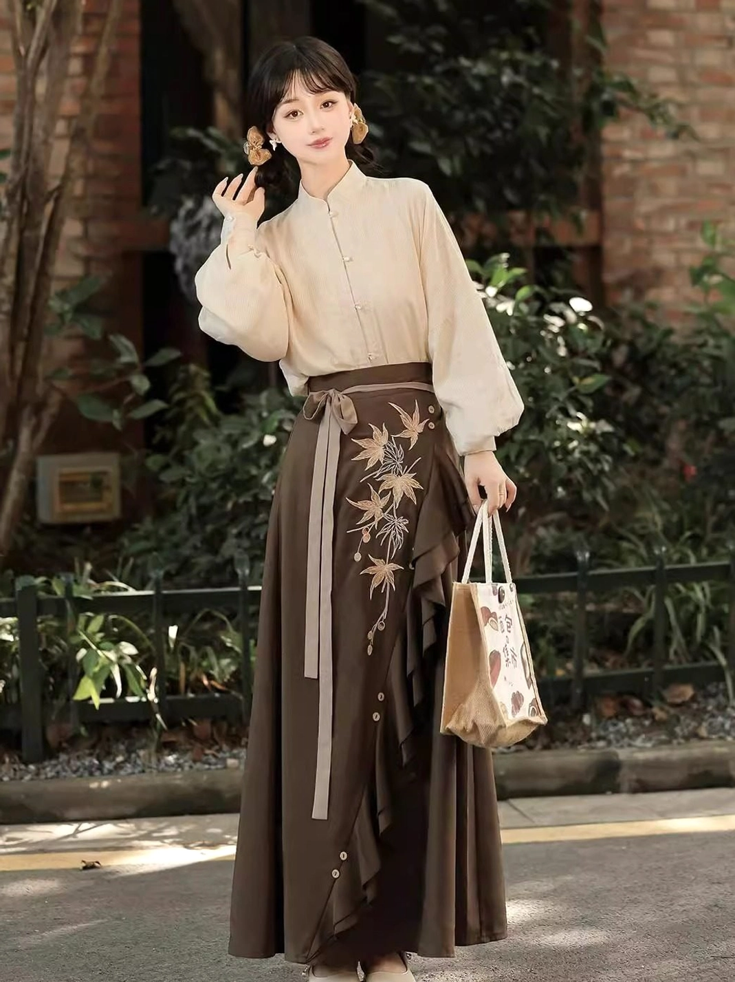 Side view of a cream stand collar long sleeve blouse paired with a warm brown embroidered skirt in a contemporary Chinese style outfit