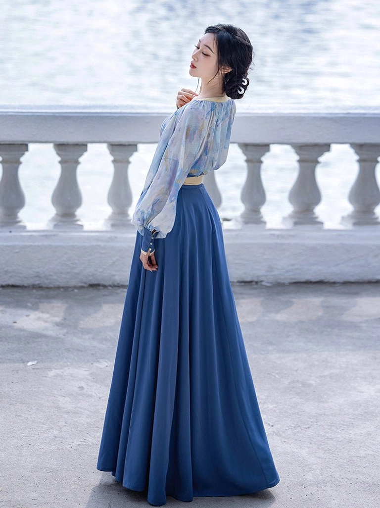 Elegant modern Hanfu two piece suit shown in a full body side view with watercolor printed top lantern sleeves and navy pleated skirt