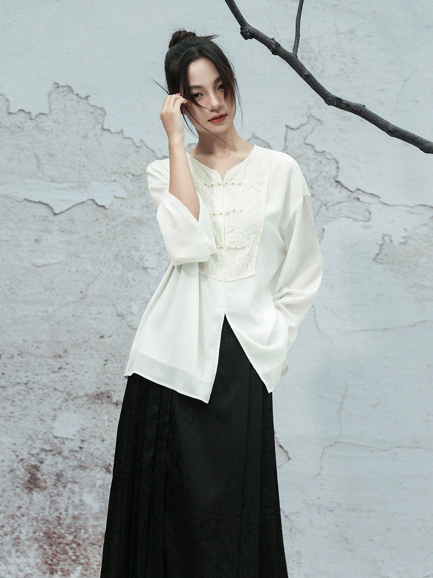 White Modern Hanfu chiffon blouse with V-neck, lace embroidered front panel, loose long sleeves, and black long skirt styled in a vintage studio