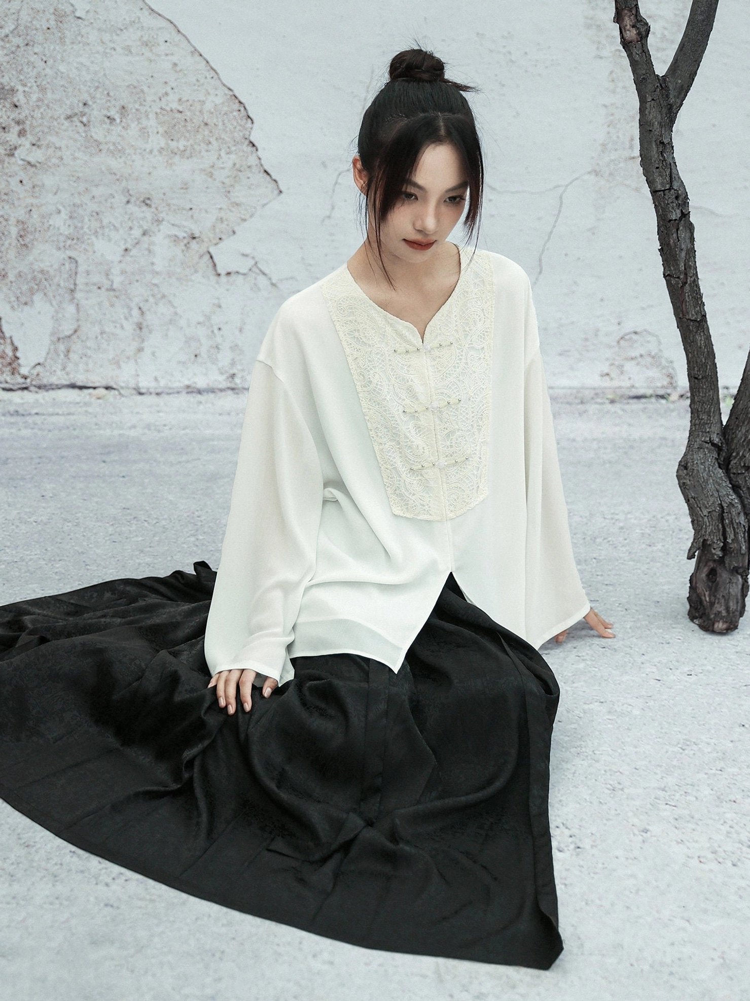 White chiffon Modern Hanfu blouse with embroidered front panel and split hem paired with a flowing black floor-length skirt