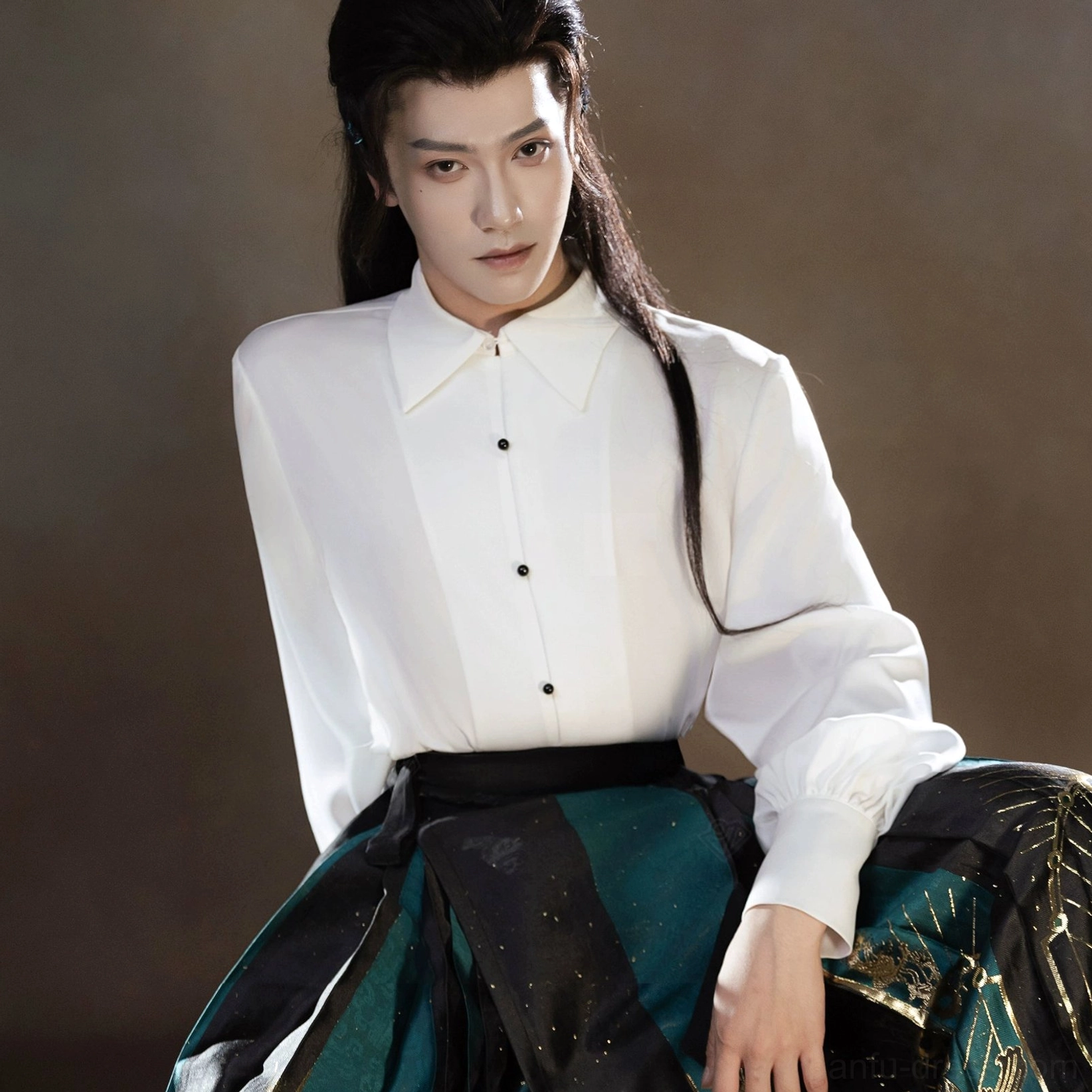 Upper body detail of a modern Hanfu white shirt with hidden buttons above a dark green and gold Sanxingdui printed mamianqun skirt