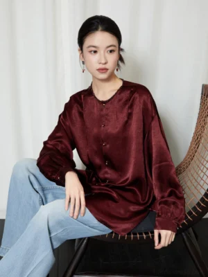 Wine red modern Hanfu crew neck satin draped shirt with loose lantern sleeves and relaxed fit styled with light blue wide-leg jeans