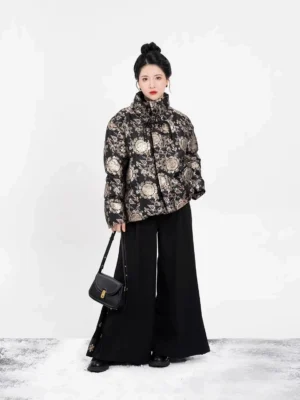 Front view of a women's modern Hanfu black puffer coat with gold floral jacquard pattern, stand collar, cropped relaxed silhouette, and Chinese-inspired winter styling