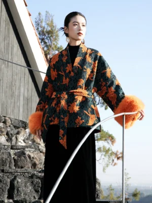 Modern Hanfu wool blend brocade jacket in dark green with orange floral jacquard pattern, fluffy orange fur cuffs, kimono collar, and waist sash worn outdoors