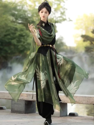 Side three-quarter view of a modern Hanfu wuxia outfit featuring black tapered bloomers, flowing green printed scarf details, and a decorative waist accessory