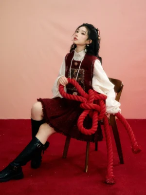 Modern Ming-inspired Chinese New Year Hanfu vest and burgundy mamian skirt full set worn by seated model with red bow decoration