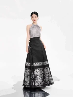 Front full-length view of a model wearing a grey modern Ming Dynasty Hanfu halter top with a black pleated Mamian skirt featuring silver floral jacquard