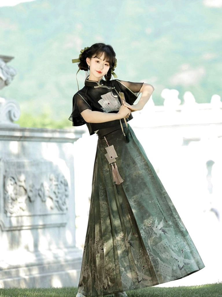 Flowing dark green Ming Dynasty-inspired Hanfu mamianqun outfit styled with a traditional folding fan outdoors