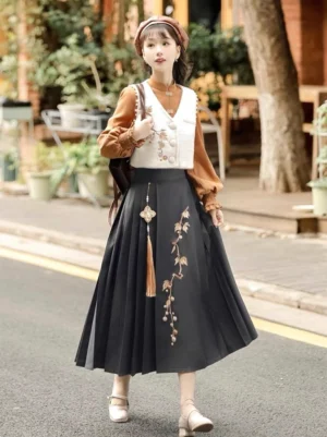 Front side view of black embroidered mamianqun horse face skirt Hanfu outfit with ivory vest, caramel Chinese blouse, and brown beret