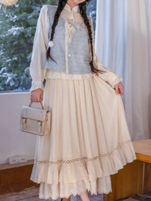 Three-quarter view of a modern Ming-style Hanfu outfit featuring a stand-collar long-sleeve blouse, light blue embroidered vest, pleated cream skirt, and lace trim