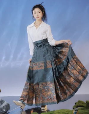 Modern Ming-style mamianqun horse face Hanfu skirt in dark teal grey with pleats, Chinese cloud and qilin brocade trim, matching waist sash, and elegant white blouse styling