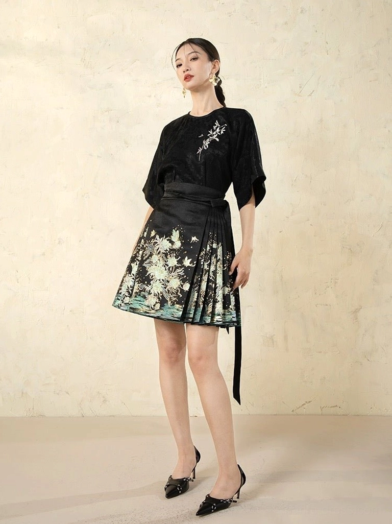 Left side full-body view of modern Ming style mini mamian skirt with black sash, pleated silhouette, and Chinese landscape print