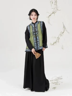 Modern Qing Han inspired porcelain green embroidered jacquard vest worn with black top and wide leg trousers in a full body front view