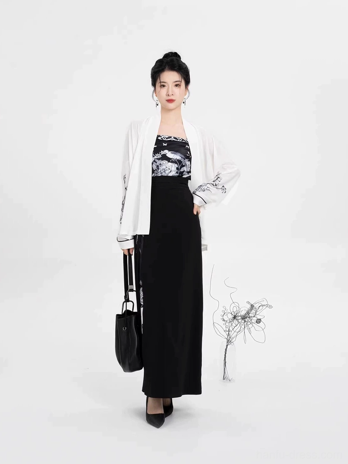 Modern Song Dynasty Hanfu model styling a black and white winged-sleeve outfit with matching handbag and pointed black heels