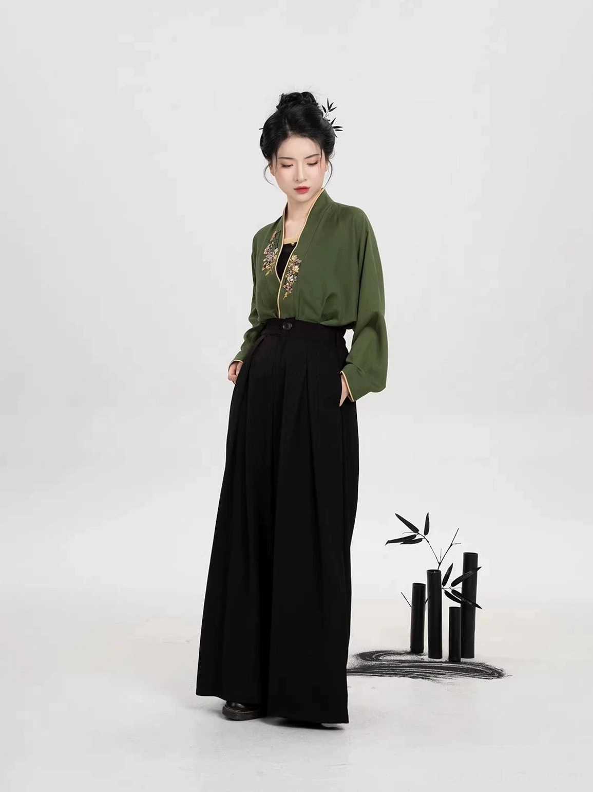 Modern Song Dynasty Hanfu pants outfit showing the floor length drape of black wide leg trousers and embroidered green top