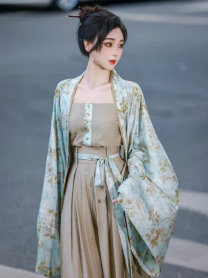 Modern Song Dynasty Hanfu commuting outfit with dusty cyan floral cardigan beige camisole and flowing wide-leg pants modeled on an urban crosswalk