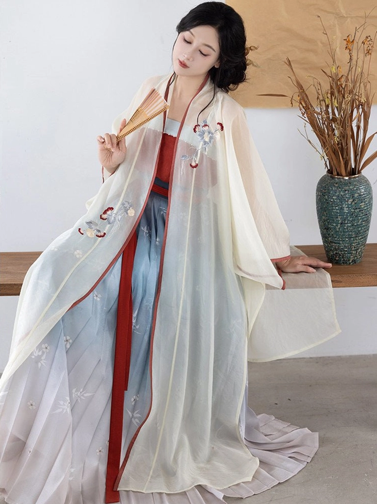 Seated front view of modern Song Dynasty Hanfu with embroidered cream cardigan, burgundy inner camisole, gradient pleated skirt, and folding fan