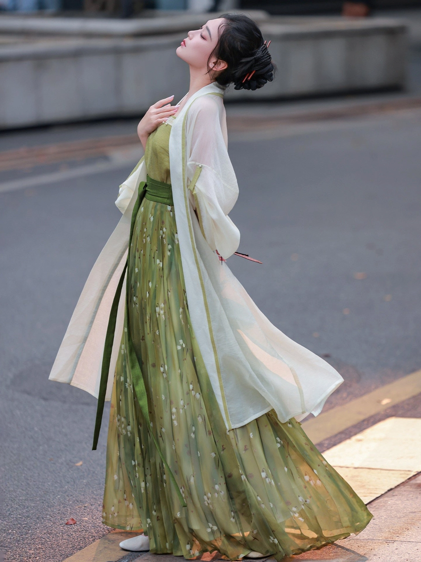 Side view of modern Song Dynasty Hanfu with flowing green floral floor-length pleated skirt and ivory sheer cardigan