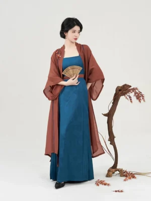 Modern Song Dynasty Hanfu outfit styled with a wooden folding fan, teal dress, reddish brown outer robe, and traditional Chinese layered silhouette