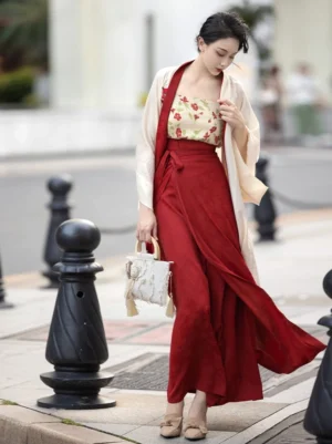 Three-quarter side view of a modern Song Dynasty Hanfu outfit with deep-red trim, flowing wrap skirt, and contemporary cultural fashion styling