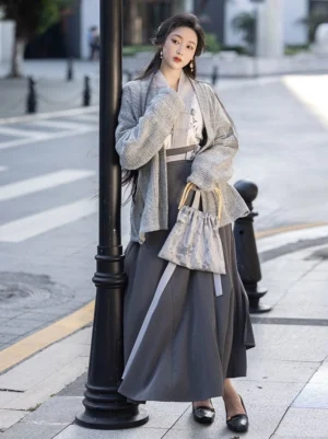 Modern Song Dynasty Hanfu set with ink floral winged sleeve top dark grey pleated wrap skirt and grey cardigan styled on an urban street