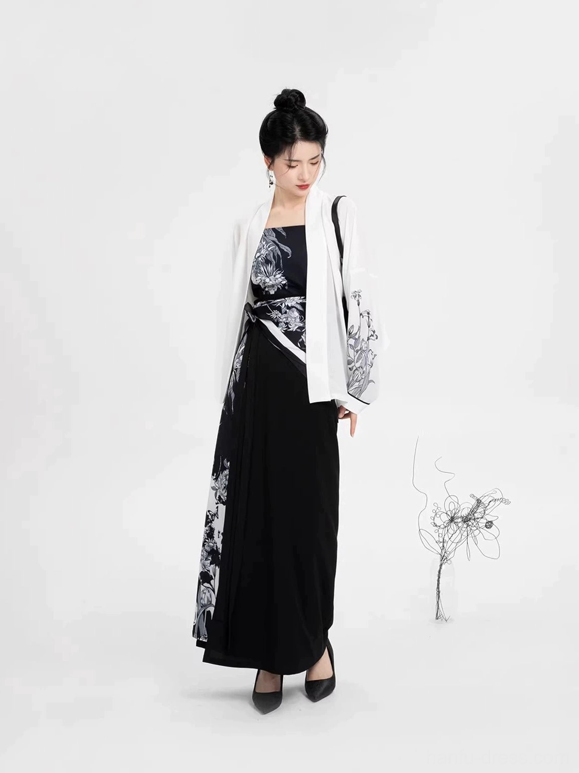 Three-quarter side view of modern Song Dynasty Hanfu outfit showing the layered camisole, winged sleeve top, asymmetrical floral panel, and flowing wrap skirt