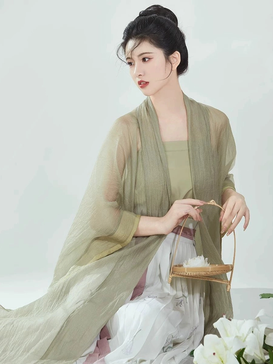 Three-quarter close-up of a modern Hanfu outfit with translucent sage green overcoat, solid camisole underneath, natural fabric texture, and bamboo-inspired styling