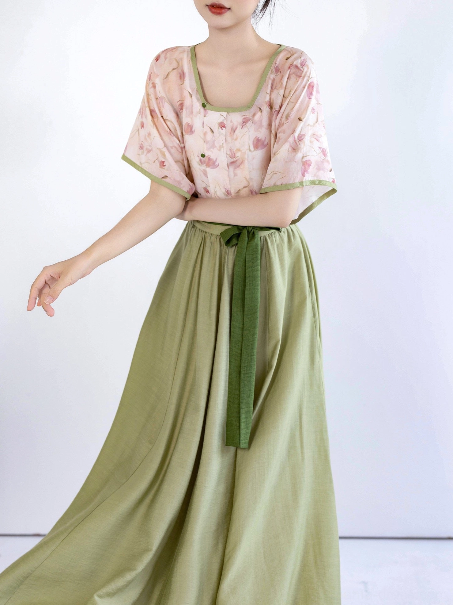 Side view of modern Song Dynasty Hanfu two-piece outfit with pink floral square-neck top and high-waisted matcha green skirt