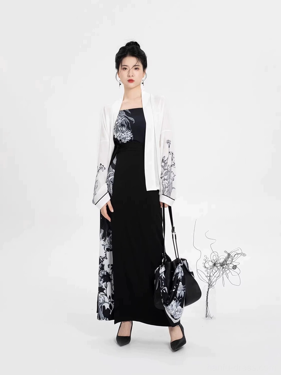 Full-body front view of a modern Song Dynasty Hanfu three-piece set with black camisole, white winged-sleeve top, ink floral prints, and long wrap skirt