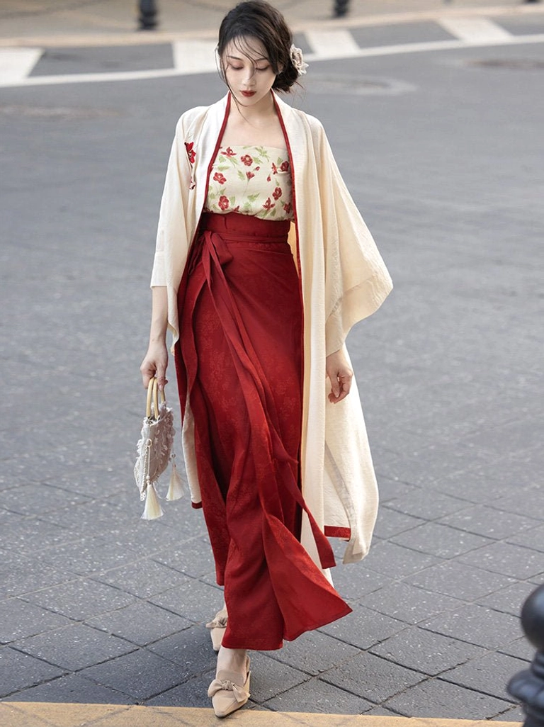 Full-body front view of a modern Song Dynasty Hanfu three-piece set with cream floral camisole, beige trimmed jacket, flowing wine-red wrap skirt, and elegant everyday styling